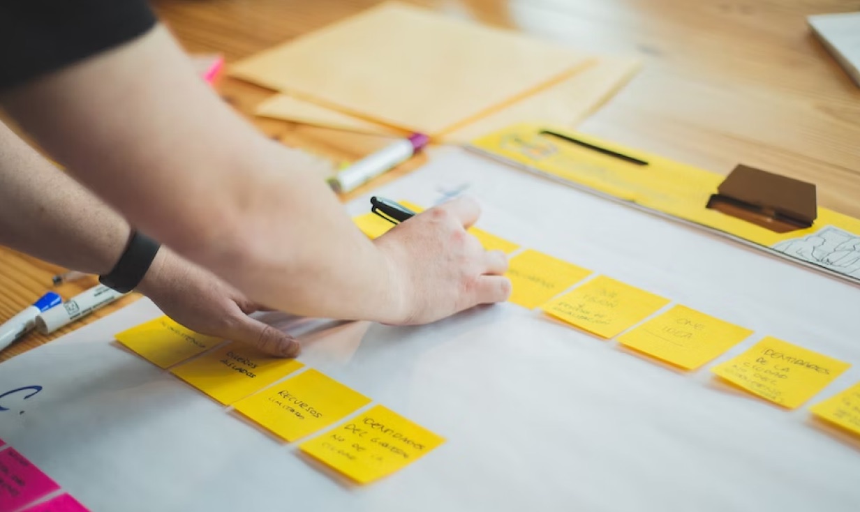 Hands arranging sticky notes during a planning workshop